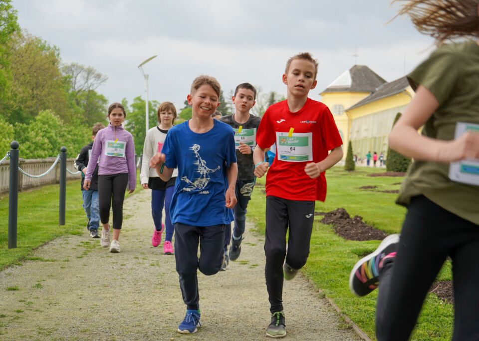 Eine Gruppe laufender Kinder mit Startnummern