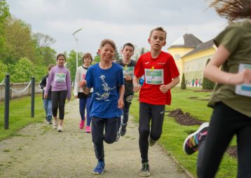 Eine Gruppe laufender Kinder mit Startnummern